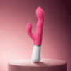Lovense Nora curved dual-stimulation rabbit vibrator on a dry pedestal with light surface droplets